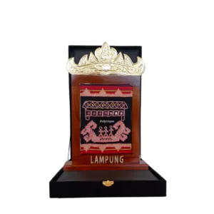 Plakat Tapis eksklusif dari kayu jati dengan motif sulaman tapis, dihiasi Siger Kuningan di bagian atas, serta ukiran kayu di bagian bawah, dilengkapi set box premium.